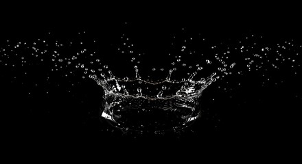 Water splash creating a crown shape with droplets flying, captured in a striking black background