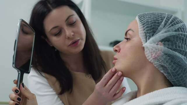 Cosmetologist communicates with the patient and shows problems on the face. Self-care beauty procedures in cosmetology. High quality 4k footage