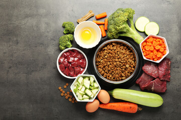 Dry pet food and natural products on grey table, top view