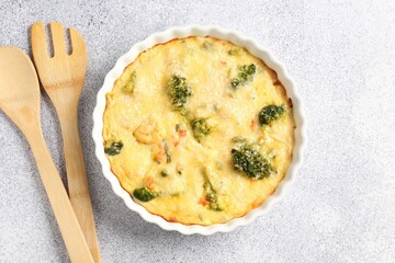 Delicious vegetable casserole and utensils on light table, top view