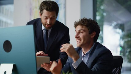 Boss showing colleague tablet ideas discussing project in modern office closeup