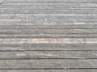 Obraz premium A closeup of a weathered wooden deck, showcasing its textured surface and natural wear patterns over time. Charming Weathered Wooden Decking Surface That Evokes Feelings of Serenity and Nature