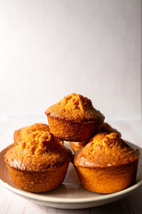 home baked lemon muffins on off white background
