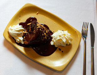 Delicious molten chocolate cake with chocolate sauce, nut crumbs and cream. Traditional French dessert
