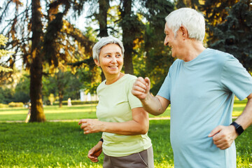 Smiling senior couple jogging in the park. Close up picture.
