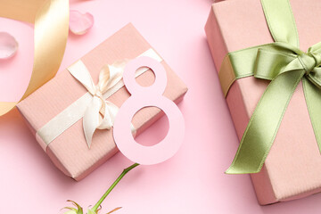 Figure 8 made of paper with gift boxes and petals on pink background. International Women's Day