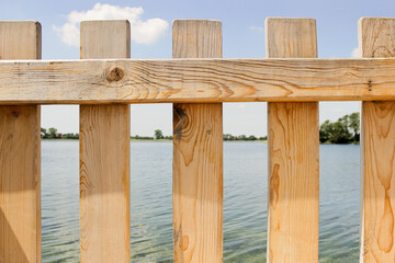 Obraz premium Light Wooden Fence with Lake View in Summer Nature Landscape