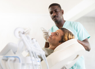Adult male patient receiving professional hardware facial procedure at cosmetic clinic using...
