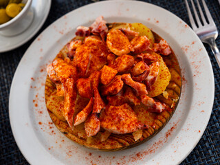 Chopped spicy boiled octopus tentacles with potato slices traditionally seasoned with aromatic smoked paprika