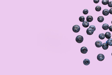 Flying sweet fresh blueberries on lilac background