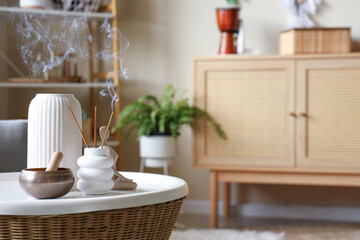 Aroma sticks with Tibetan singing bowl and vase on table in witch's room, closeup