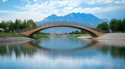 Scenic arched bridge over calm river with mountain backdrop.