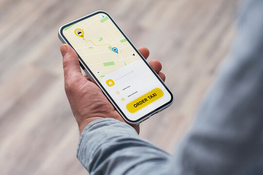 A man uses a taxi app on his smartphone to order a taxi.