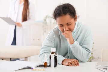 African-American teenage girl coughing in doctor's office