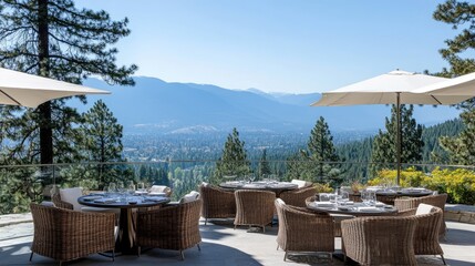 Outdoor resort dining area with wicker chairs, umbrellas, and stunning mountain views.