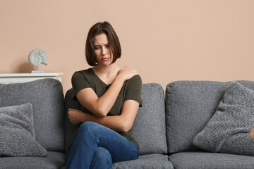 Obraz premium Depressed young woman sitting on sofa in living room