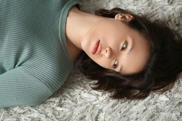 Naklejka premium Desperate, depressed young woman lying on floor at home. Closeup