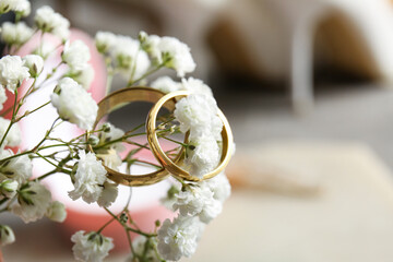Wedding rings on gypsophila flower on blurred background