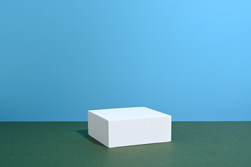 Podio rectangular sobre fondo de color verde y azul