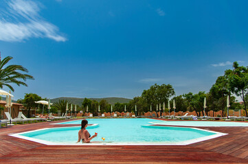 young woman relaxing in the pool in sardinia resort