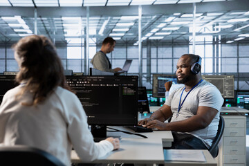 Engineer in data center coordinating deployment of server architecture, improving data processing speed in client workload capacity. Server room expert configuring and testing hardware