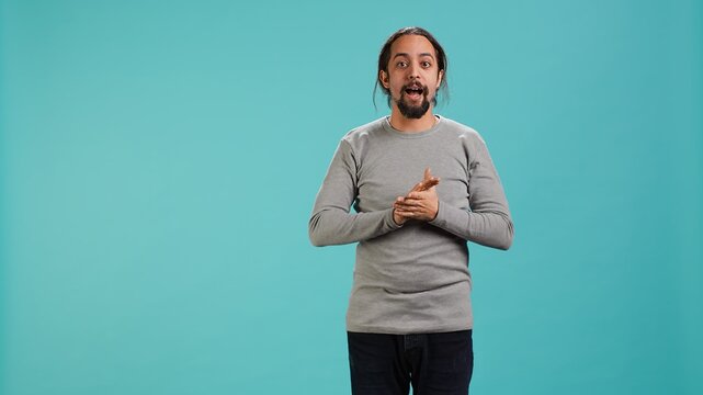 Disappointed man admonishing friend over debacle, isolated over blue studio background. Upset person in disagreement with mate, pointing finger and lecturing him, camera A