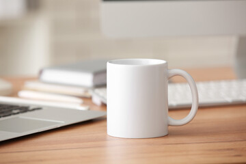 White ceramic cup on table near notebooks in office