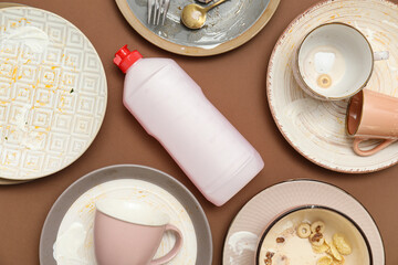Dirty dishes and detergent on brown background. Top view
