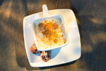 flat lay of warm Cinnamon Drink milk in a White Mug with Chocolate Truffles