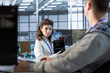 Programmers using tablet in data center, coordinating deployment of server architecture, improving...