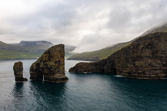 Majestic Cliffs and Serene Waters of Faroe Islands Captured by Drone