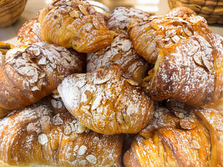 Golden, Flaky Almond Croissants Topped with Powdered Sugar Fresh from the Bakery Oven