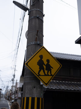 Silhouette Children Crossing Sign on a Quiet Japanese Street with Traditional Architecture
