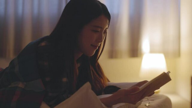 布団を被り読書をする日本人の女性	