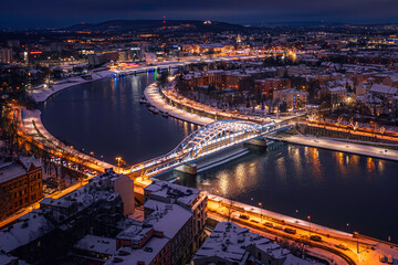 Fototapeta premium Panorama of Vistula river in Krakow, Poland with illuminated bridge at winter night.