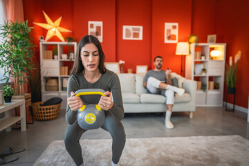 woman do squats with kettle bell, home workout