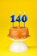 Happy birthday cake with number 140 candle - Card on a yellow background.