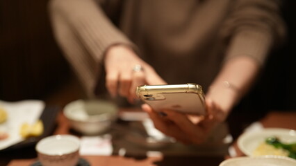 女性がスマホを操作して写真を撮る