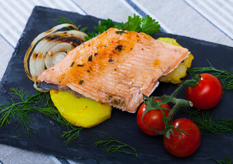Slate with tender trout fillet, potatoes, cherry tomatoes and greens