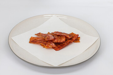 Crispy bacon strips isolated on culinary presentation food art clean style