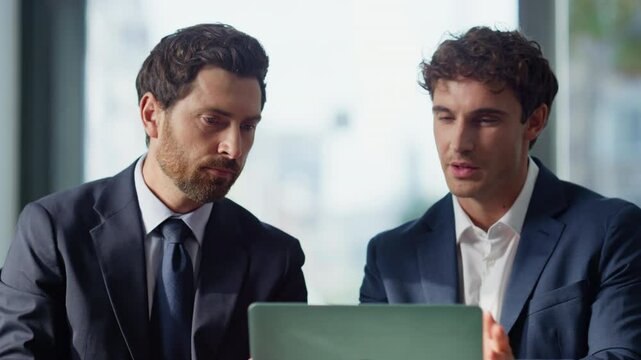Talking partners looking laptop at panoramic cafe closeup. Business colleagues
