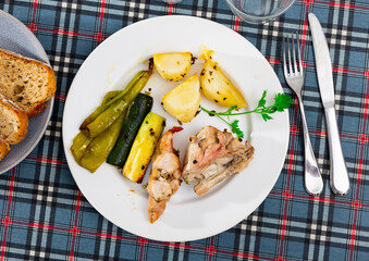 Dietary roasted rabbit served with potato and grilled pepper and zucchini for dinner