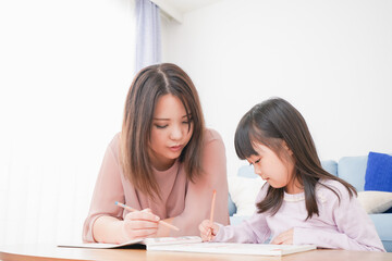 Fototapeta premium お母さんと一緒にお勉強をする小さな女の子