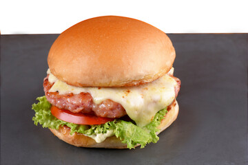 beef burger with sandwich bun salad onion and cheese fast food isolated on wooden table