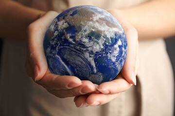 Planet in our hands. Woman holding Earth model, closeup