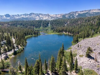 Aerial view of Twin Lakes in Mammoth Lakes, California, USA. People enjoy kayaking on the lake surrounded by pine trees and mountains.  Mammoth Lakes, California, USA