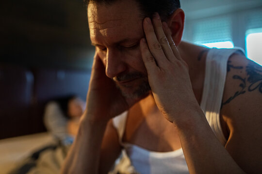 Man struggling with insomnia and stress in bedroom