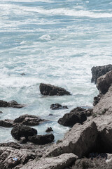 Powerful waves crash against the rocky coastline, 