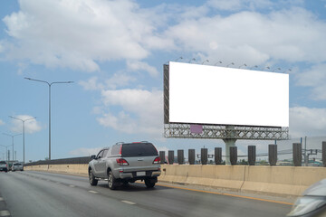 A large, blank billboard on the side of a highway. The billboard is white. It is located in a rural area.