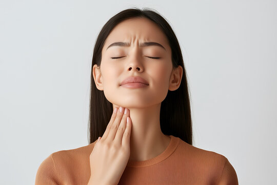 Asian girl with neck pain. Concept of sore throat, pharyngitis, laryngitis, thyroiditis, choking